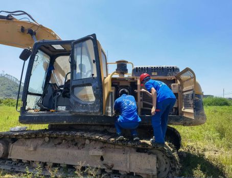 Technicians servicing a Yuchai excavator in the field.